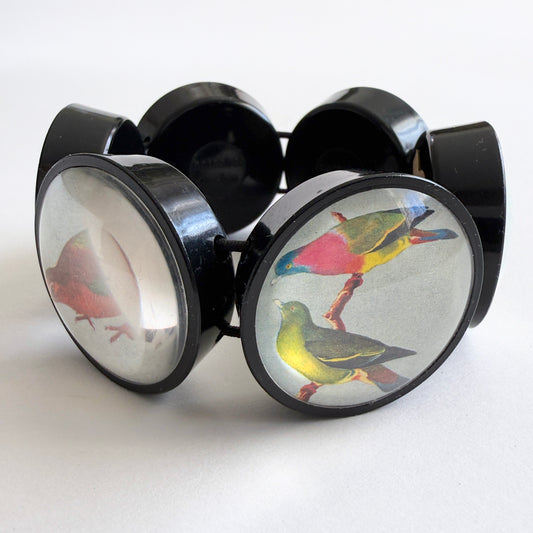 hotcakes black circular disks with colorful bird illustrations on a white background