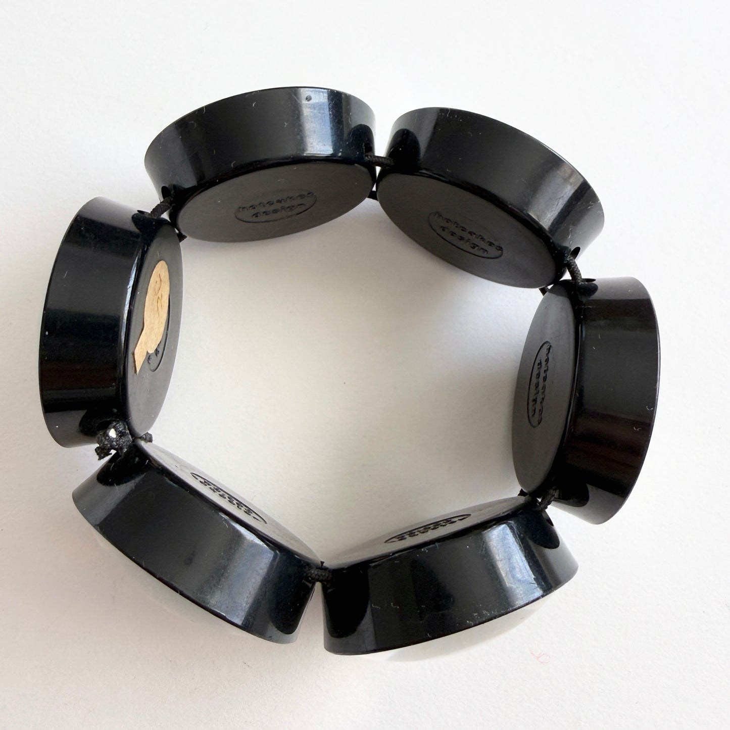 hotcakes black circular disks bracelet on a white background
