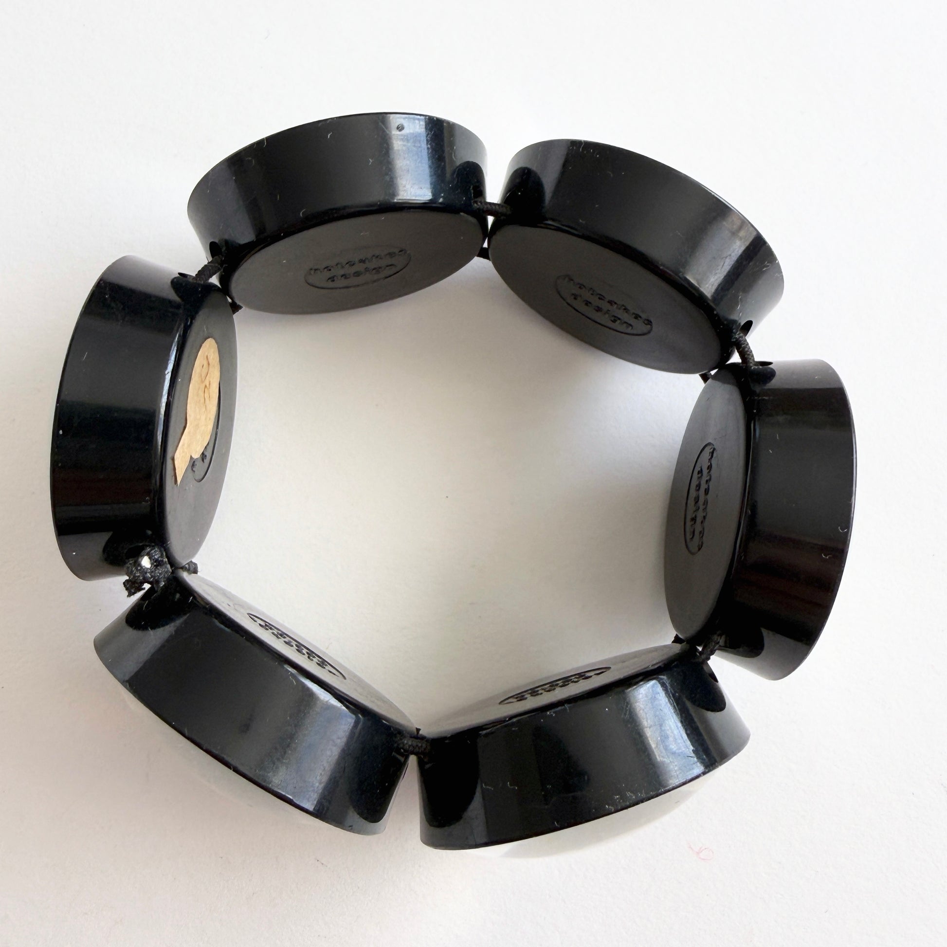 hotcakes black circular disks bracelet on a white background