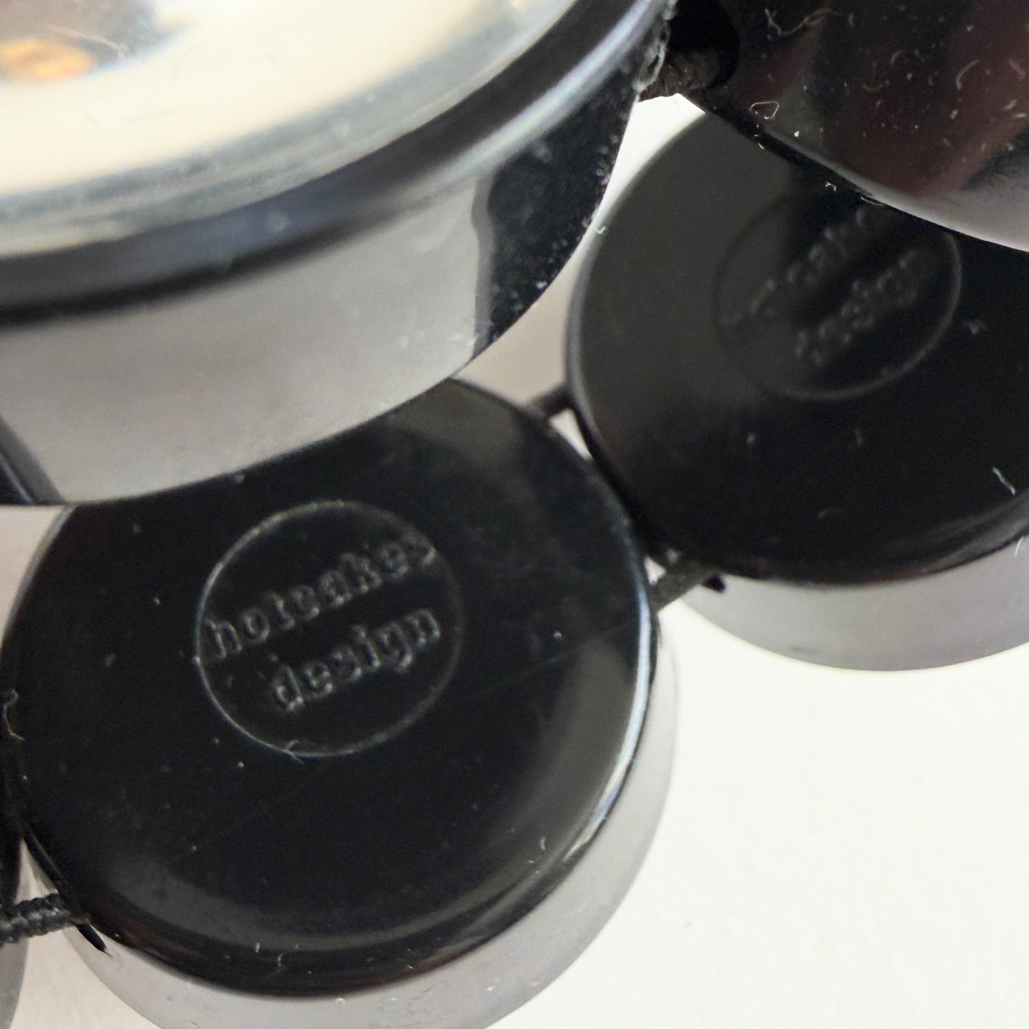 Close-up of a black 'Hotcakes Design' branding on a white background