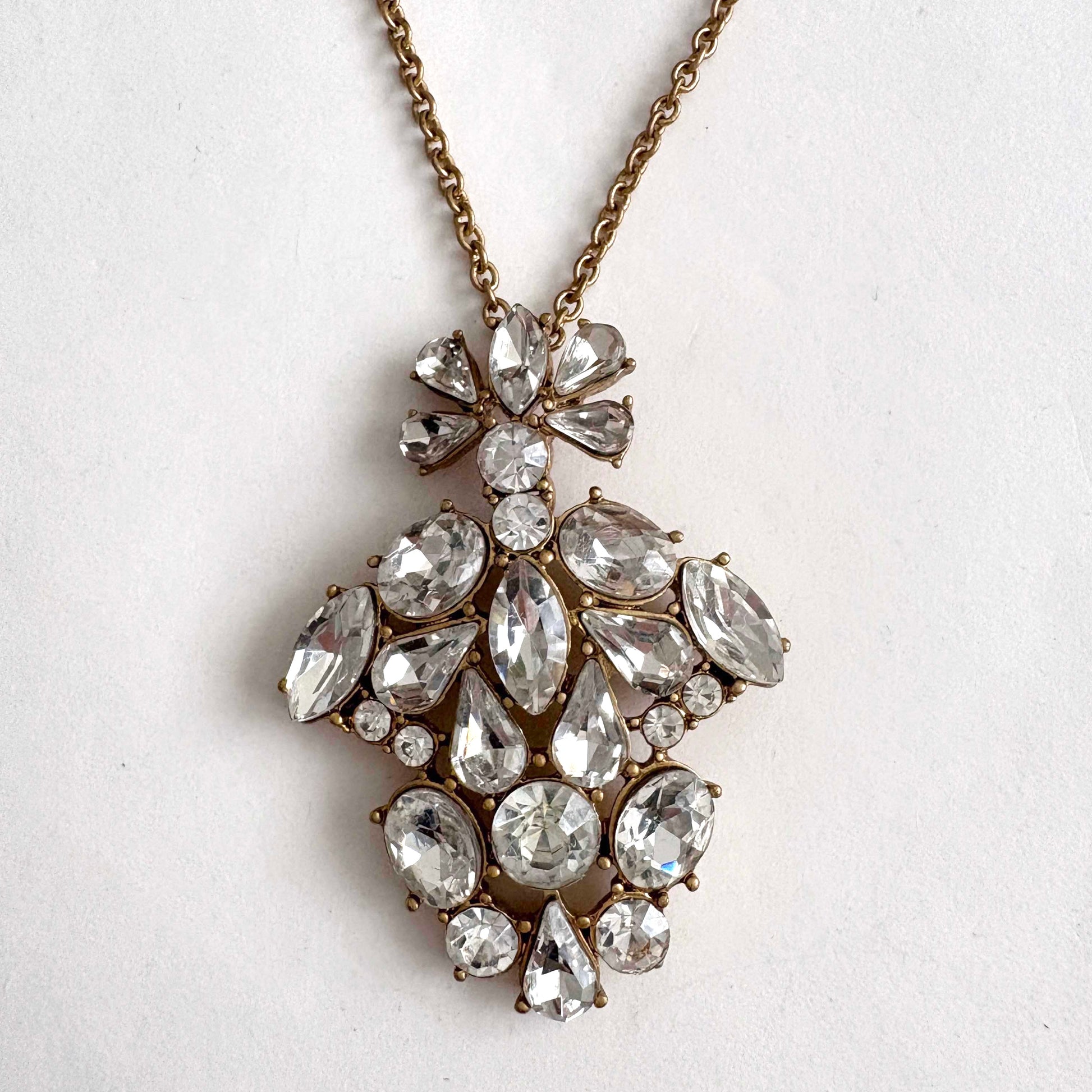 jcrew necklace with a large, ornate pendant featuring clear rhinestones on a light gray background