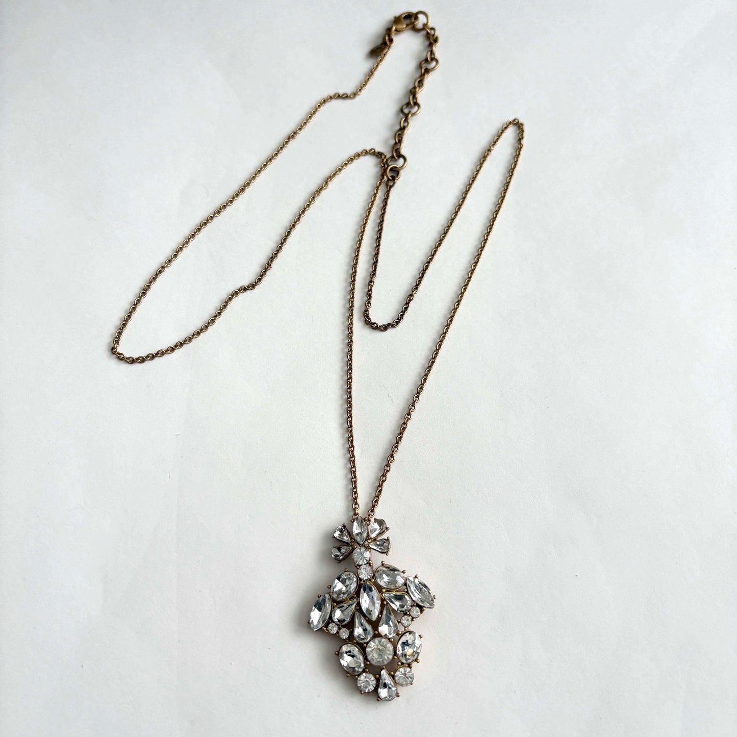 jcrew necklace with a large, ornate pendant featuring clear rhinestones on a light gray background