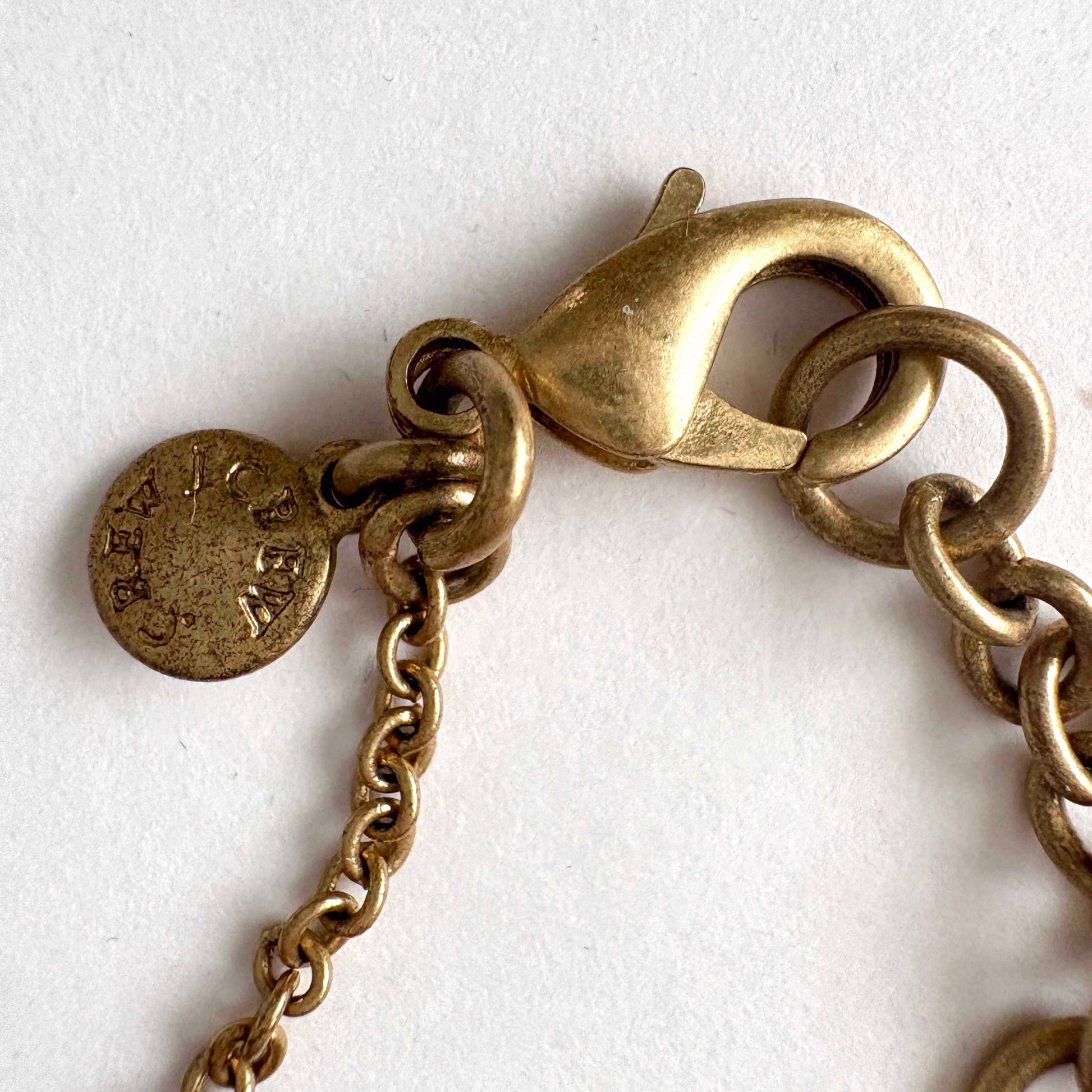 Close-up of a gold chain bracelet with clasp on a white background