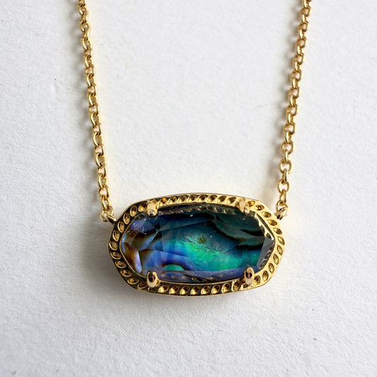 Necklace with a gold chain and colorful pendant on a white background