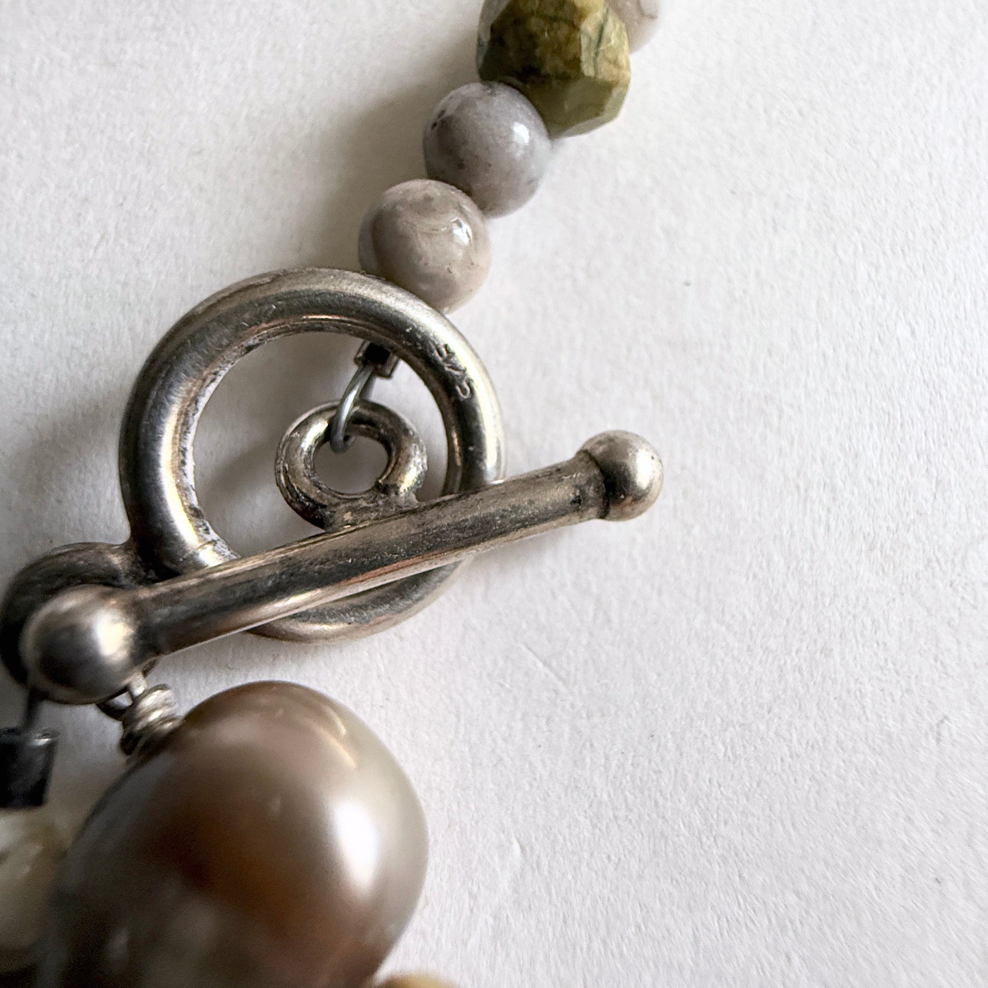 The secure sterling silver toggle clasp and hand-strung bead construction of the Littoral Artisan Moonstone Strand.