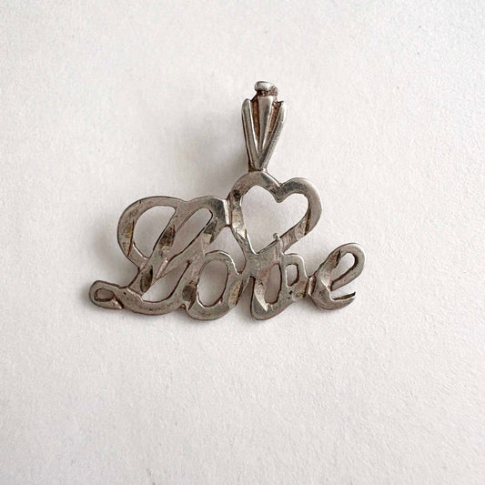 Silver 'love' pendant on a white background