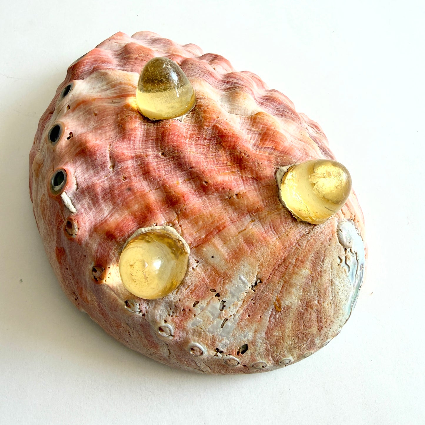 The base of the bowl showing the secure attachment of the hand-cast Lucite tripod legs and the natural exterior texture.