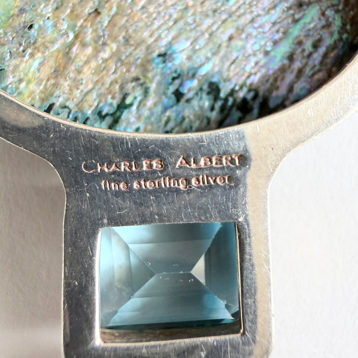 The back of the pendant showing the authentic 'Charles Albert / fine sterling silver' hallmark and the high-luster .950 silver finish.