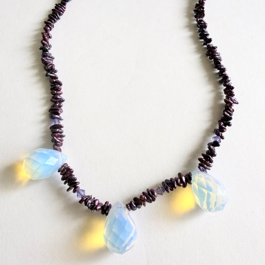 Close-up of the faceted opaline glass drops, showing the ethereal blue and honey-toned light diffusion.