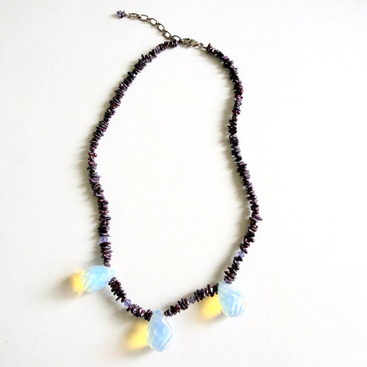 The 'Glow-Worm' necklace featuring deep merlot freshwater pearl chips and three faceted opaline glass drops on a white background.