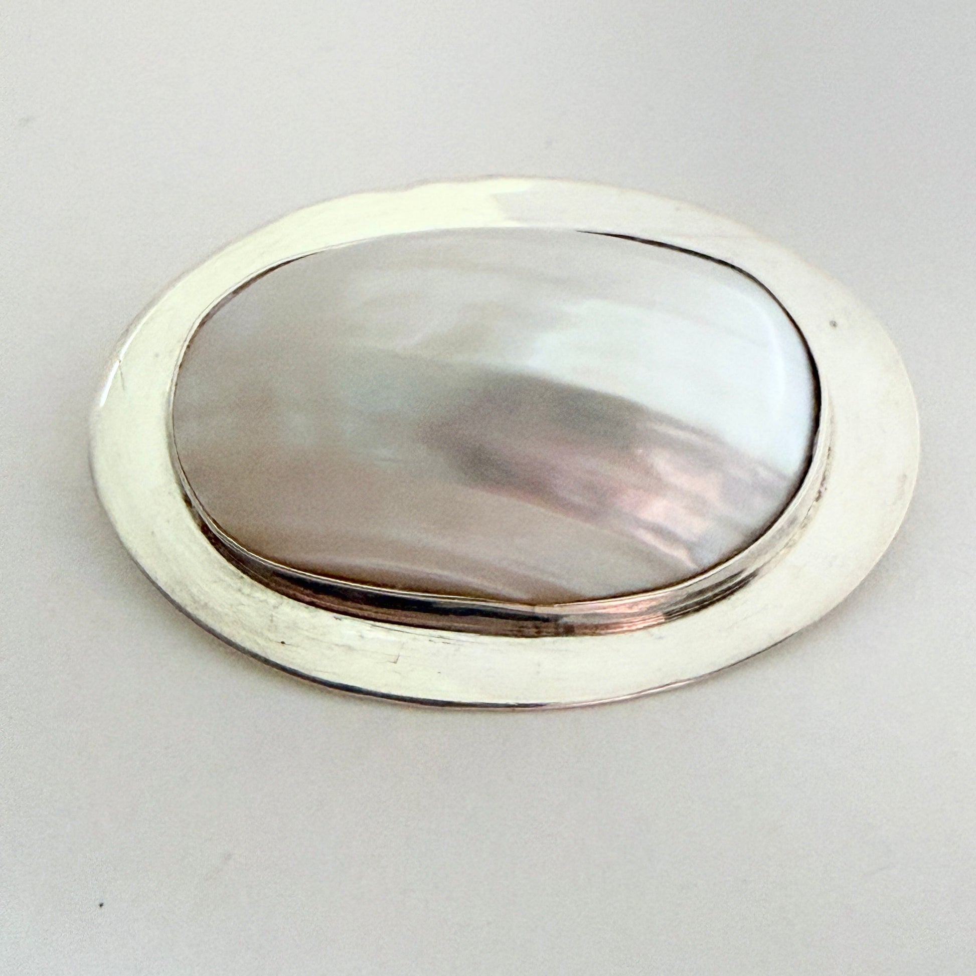 Full view of the 'Great Falls' archival brooch featuring a high-dome mother of pearl cabochon in a modernist sterling silver frame.