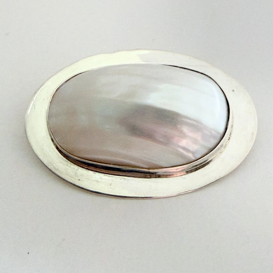 Full view of the 'Great Falls' archival brooch featuring a high-dome mother of pearl cabochon in a modernist sterling silver frame.
