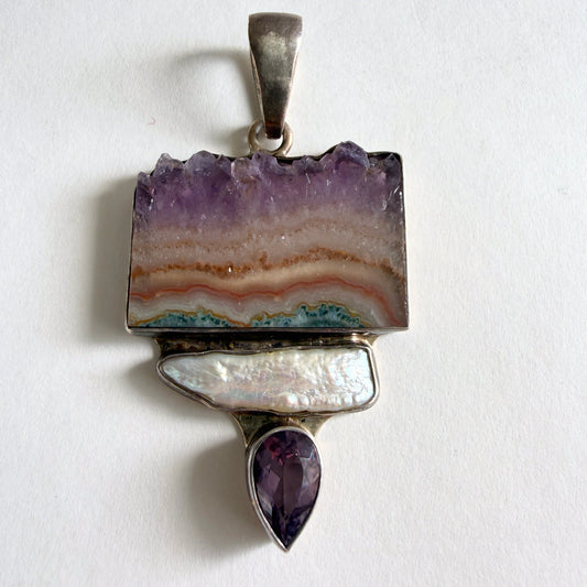 The 'Labyrinth' Charles Albert pendant featuring an amethyst stalactite slice, a baroque pearl, and a faceted amethyst drop in .950 fine sterling silver.