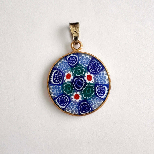 round floral Millefiori glass pendant with gold frame on a white background