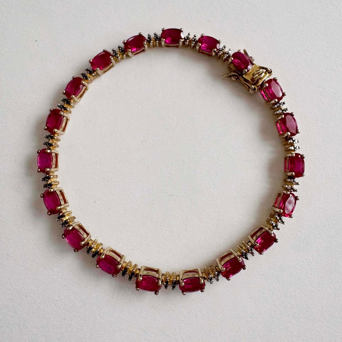 bracelet with ruby gemstones on a light gray background