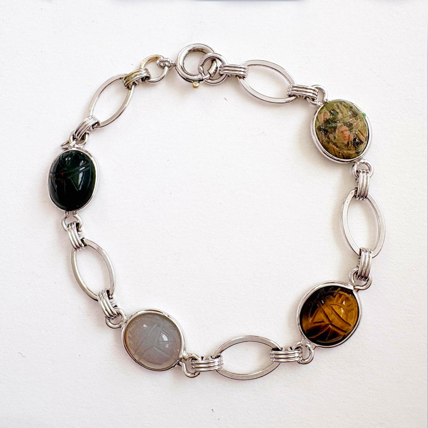 white gold filled bracelet with oval scarab gemstones on a white background