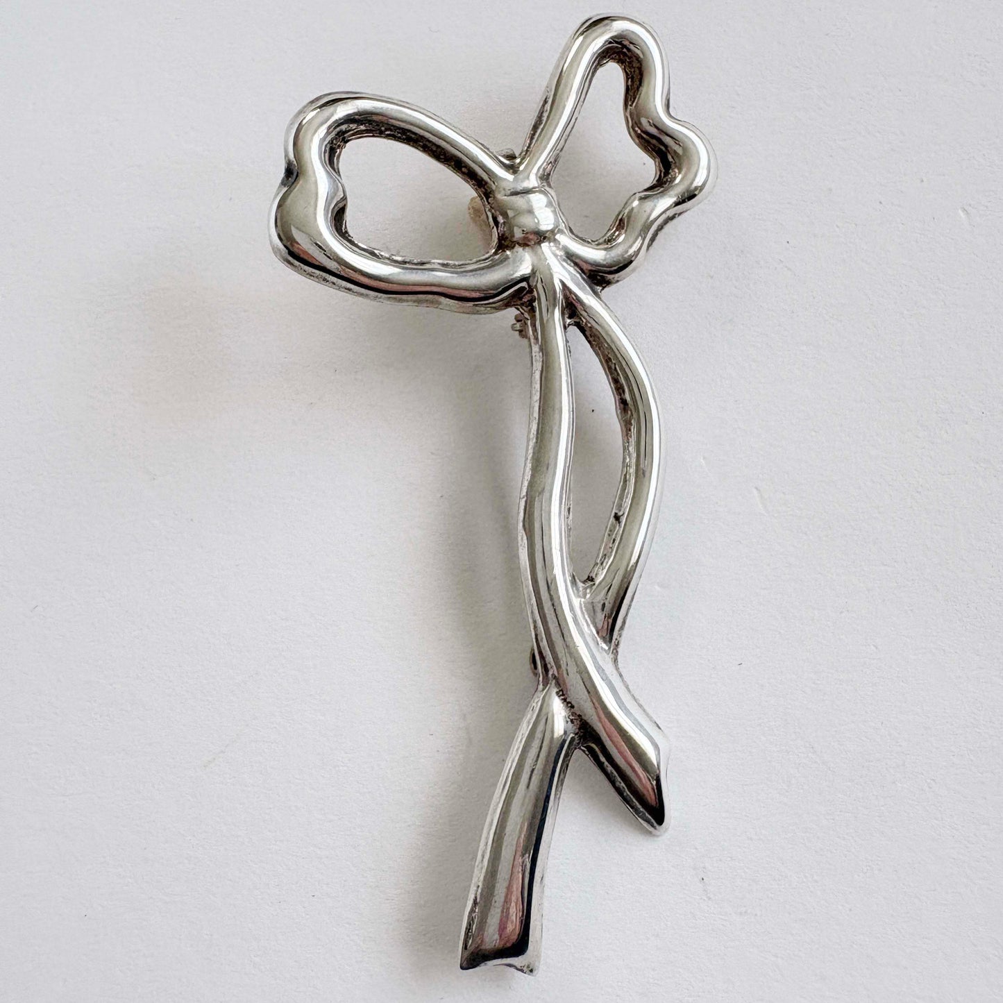 sterling Silver bow brooch on a light gray background