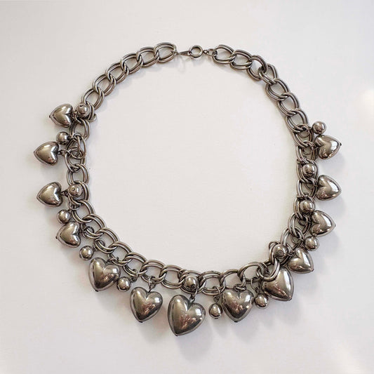 silver chain necklace with heart-shaped charms on a white background