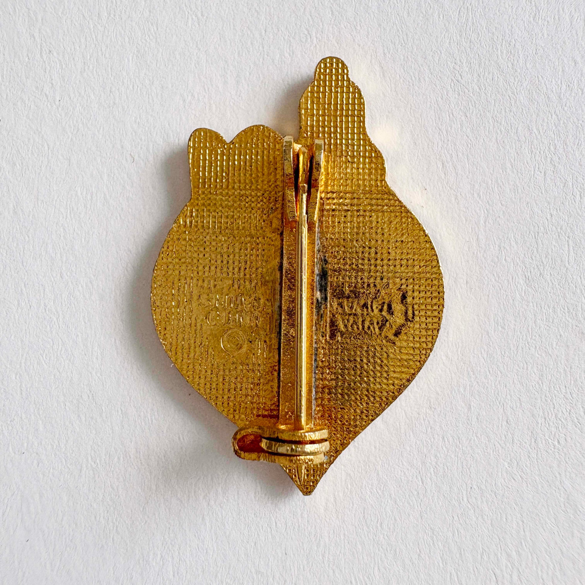 Gold-colored pin on a white background