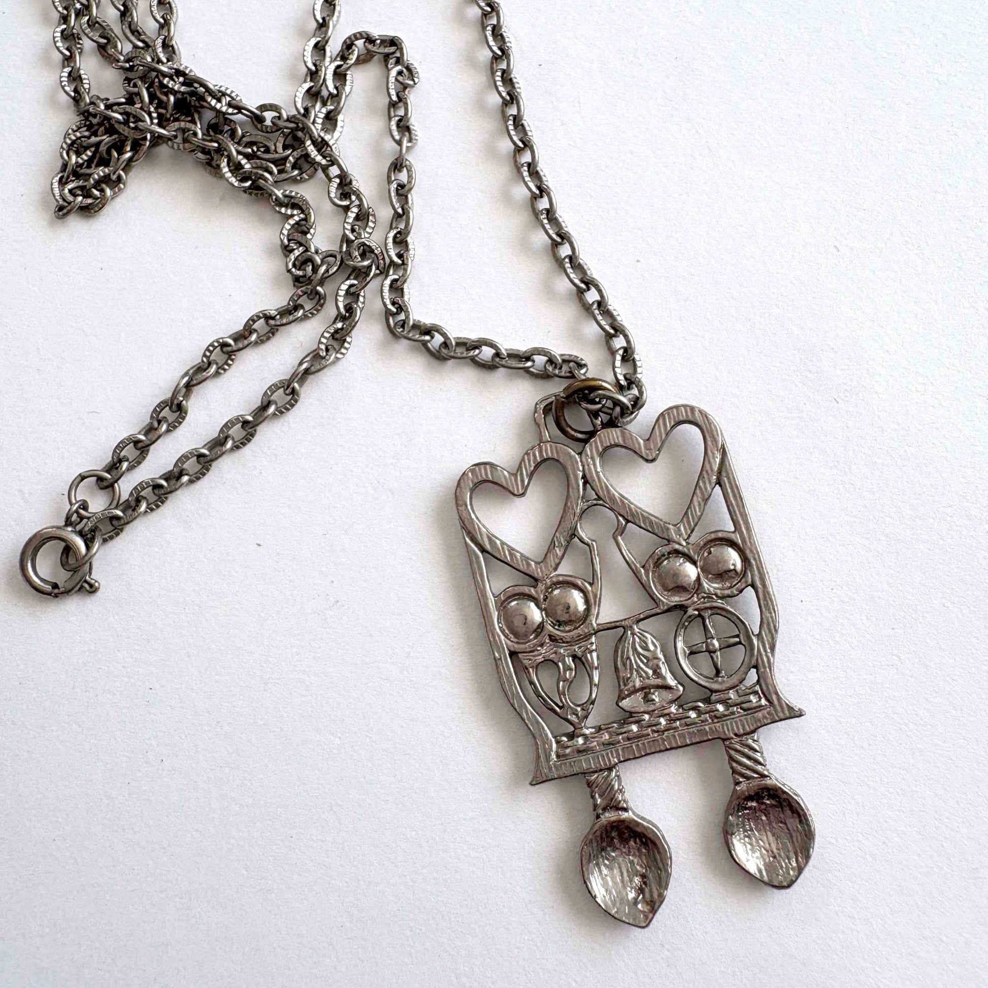 Silver pendant necklace with Welsh Spoon heart design on a white background