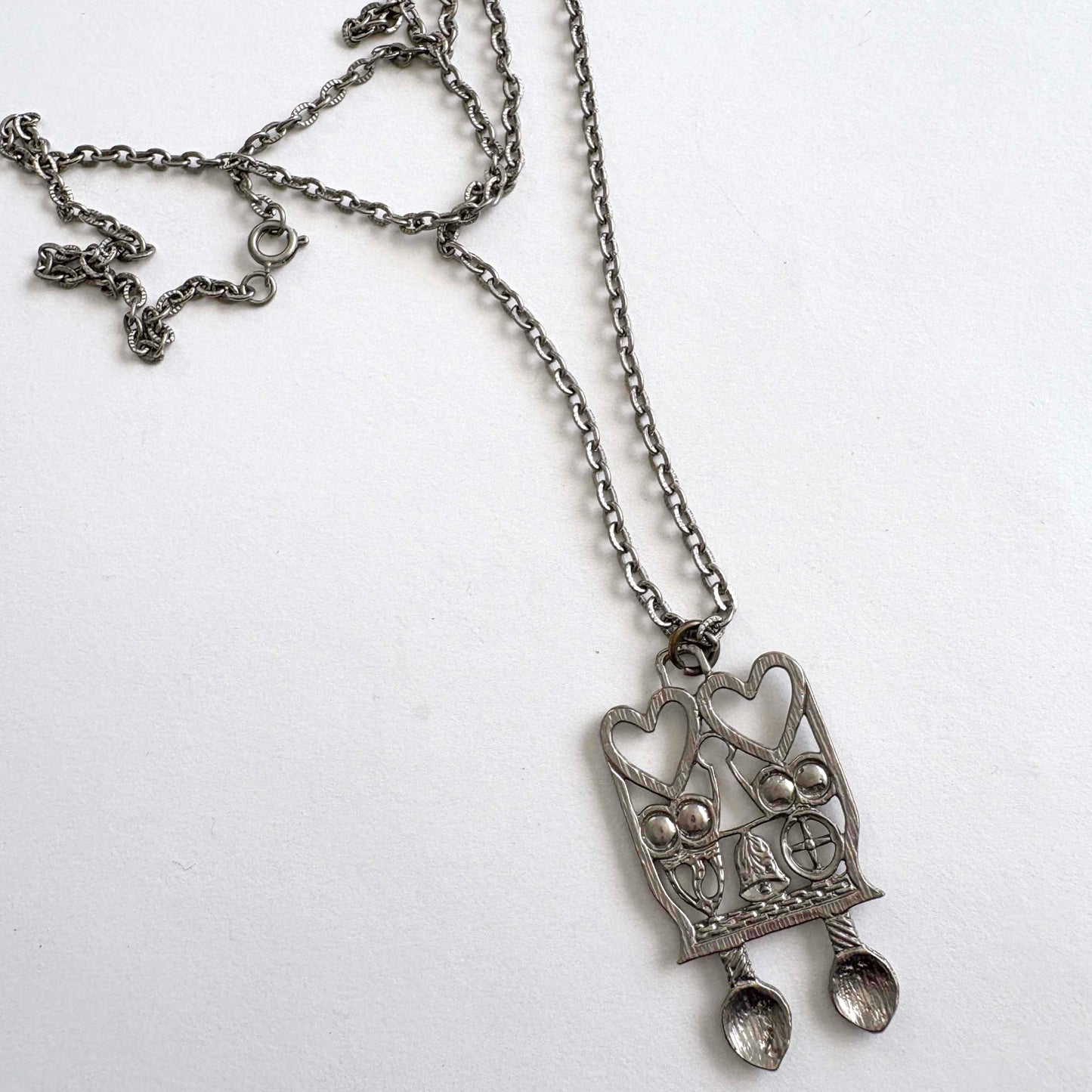 Silver pendant necklace with Welsh Spoon heart design on a white background