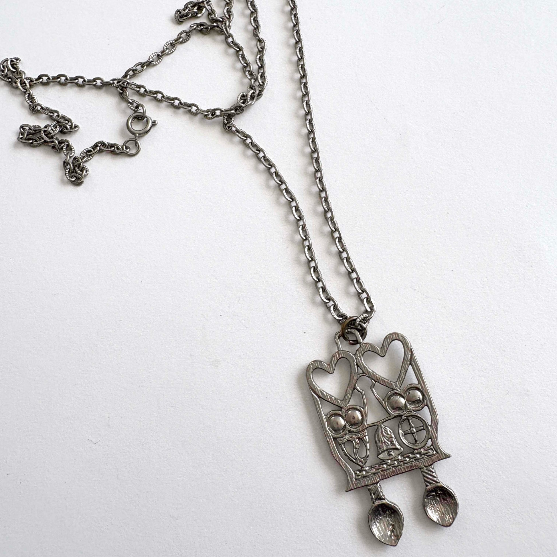 Silver pendant necklace with Welsh Spoon heart design on a white background